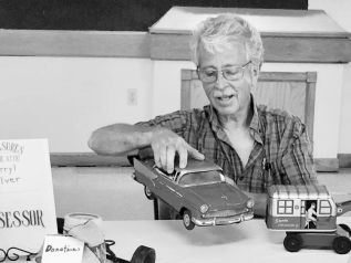 Antique Dealer Darryl Silver inspects a metal toy car.